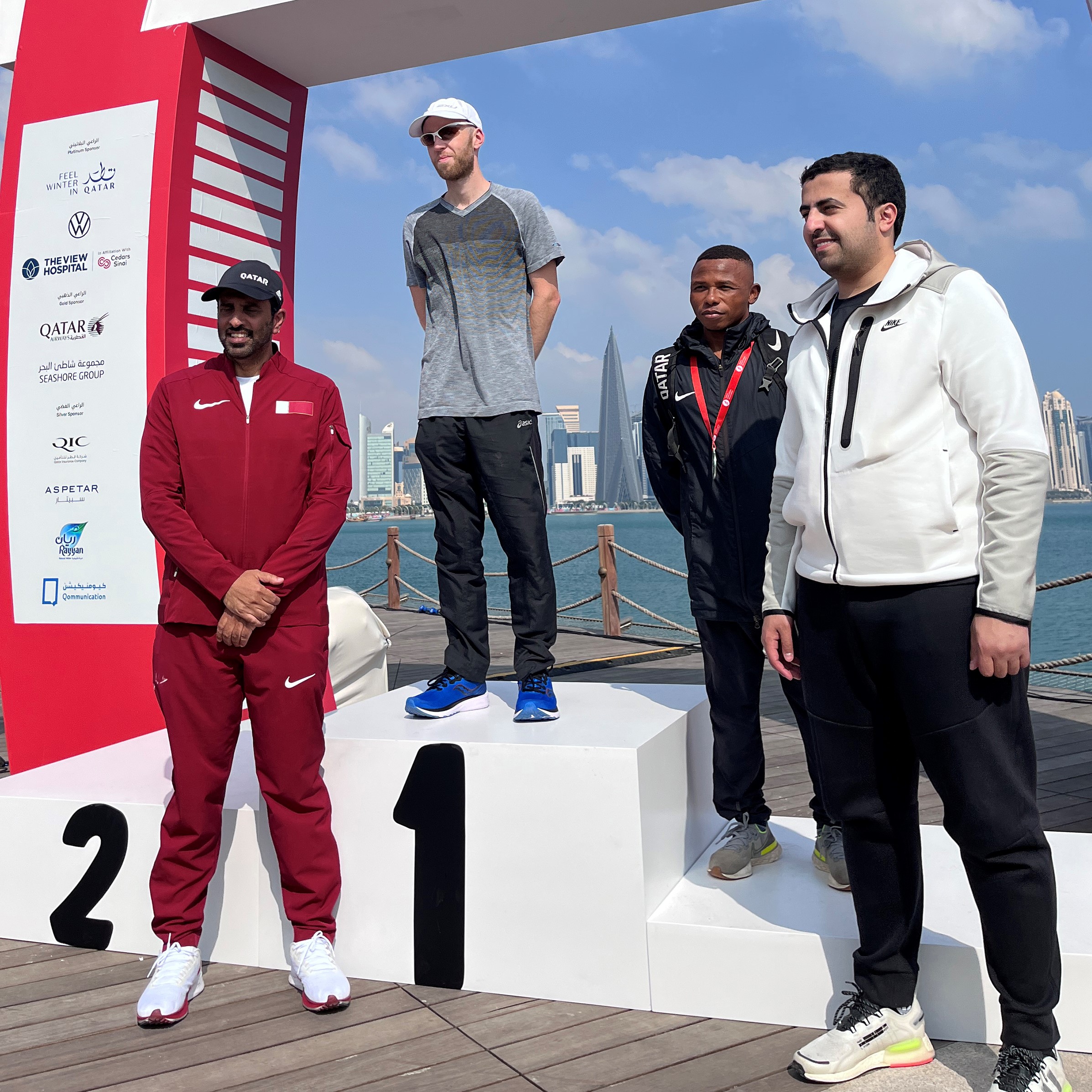 Image shows marathon competitors on podium in Qatar.